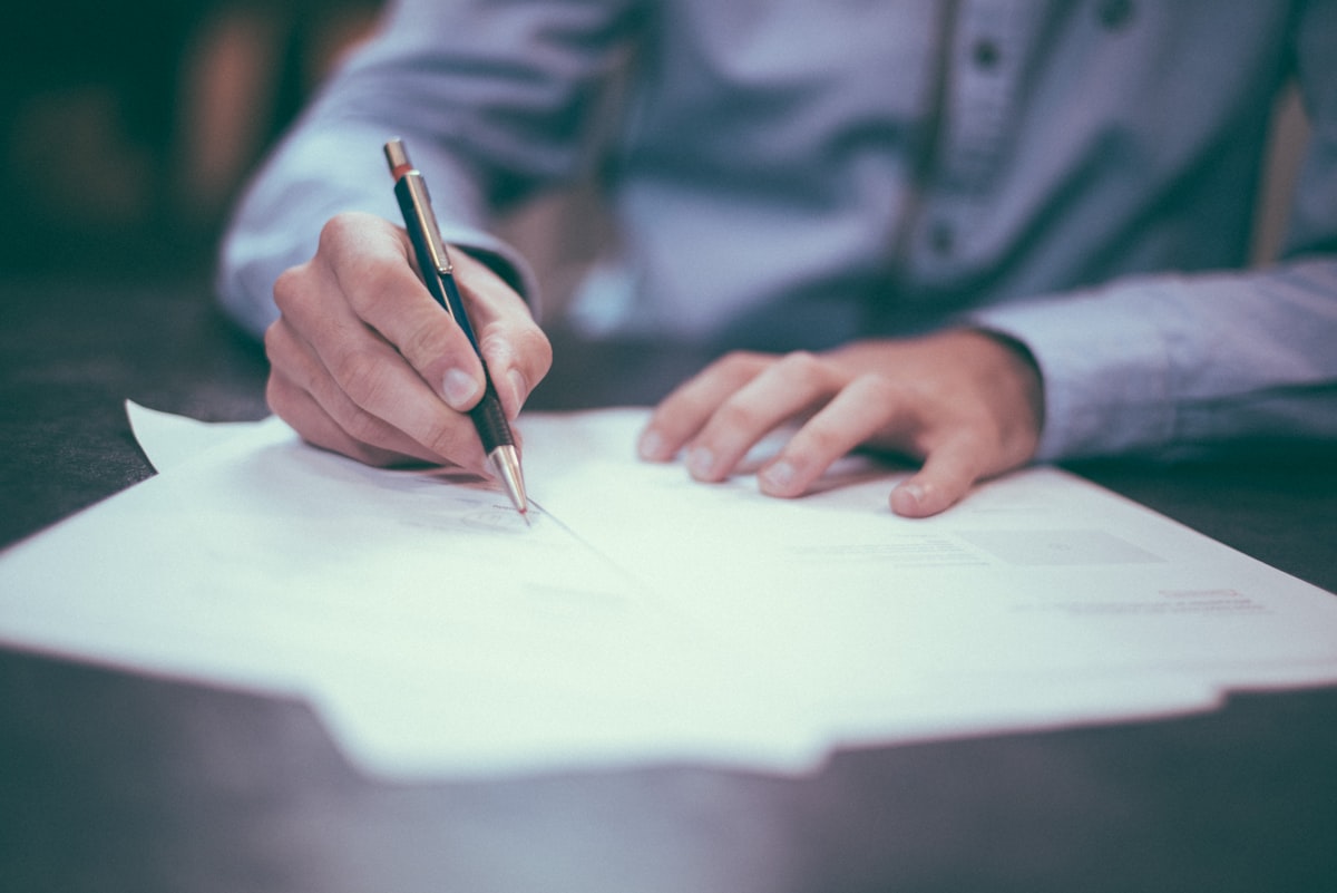 Une personne signant un document avec un stylo